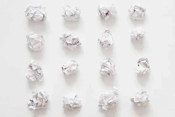 Residuos arrugado bolas de papel filas fondo blanco — Foto de Stock