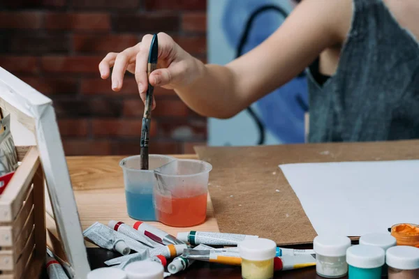 Creative hobby woman painting washing paintbrush — Stock Photo, Image