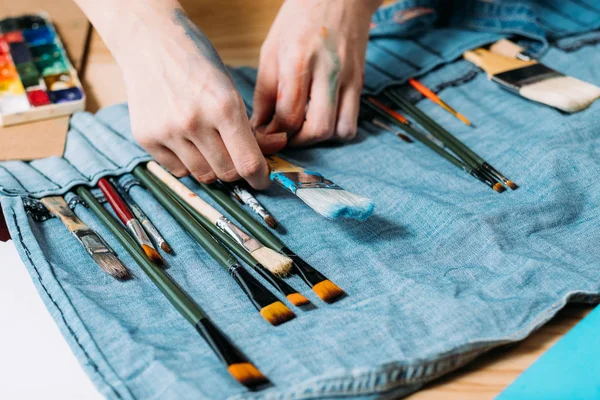 Painter kit artist choosing paintbrush denim bag — Stock Photo, Image