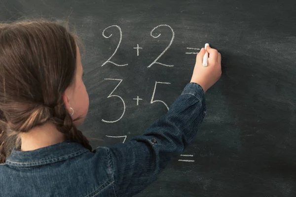 Escola primária menina do ensino fazer chalkboard matemática — Fotografia de Stock