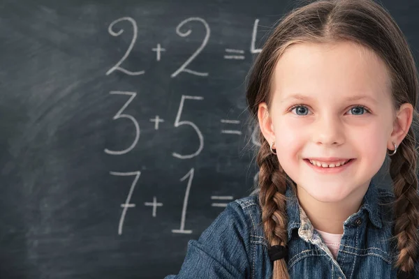 Matte klass Smart lycklig ung flicka svarta tavlan — Stockfoto