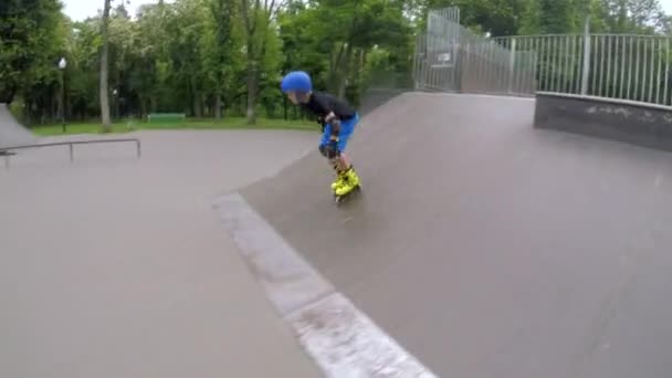 Sportiga barn fritid pojke rullskridskor skridskoåkning ramp — Stockvideo