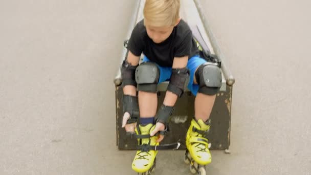 Equipamentos esportivos extremos menino corrigir patins — Vídeo de Stock