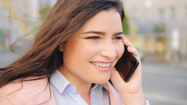 Chatterbox lachende vrouw praten mobiele telefoon straat — Stockvideo