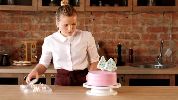 Кондитер-кондитер, украшающий розовый торт — стоковое видео
