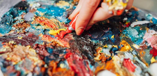 塗料を混ぜるカラフルなパレット左利きのアーティスト — ストック写真