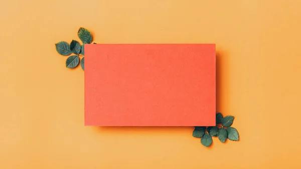 Gratulationskort rött papper lämnar orange bakgrund — Stockfoto