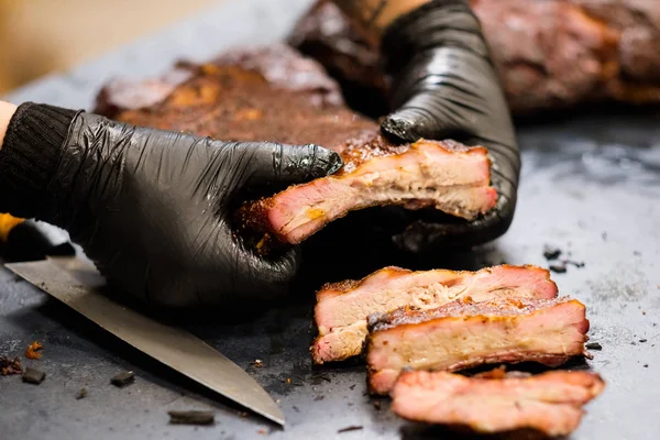 Kulinaarinen mestarikokki käsineet savustettu sianlihaa kylkiluut — kuvapankkivalokuva