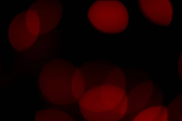 Rojo bokeh luces lente llamarada fondo negro — Foto de Stock