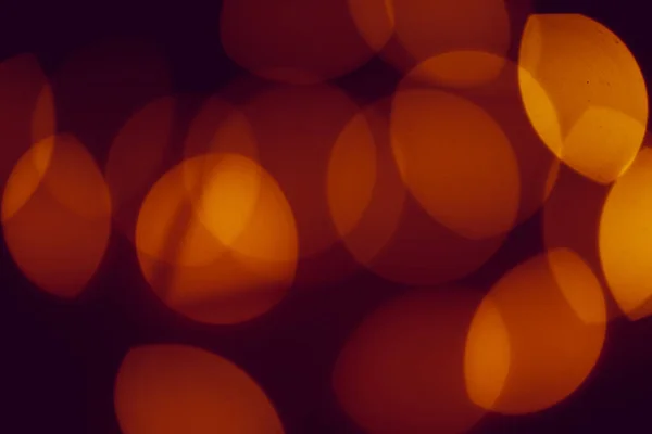 Turuncu bokeh ışıkları koyu arkaplanı aydınlatır — Stok fotoğraf