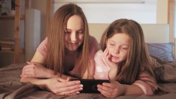 Madre hija ocio viendo vídeo teléfono cama — Vídeos de Stock