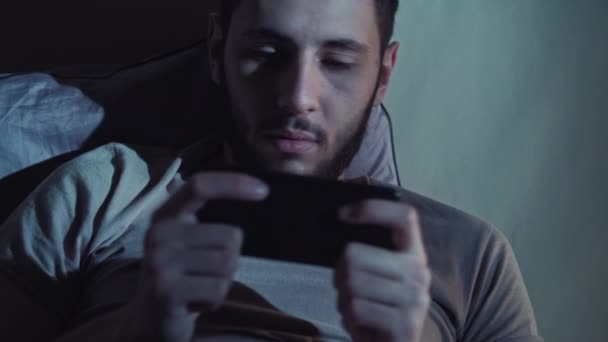 Noche teléfono juego cansado hombre jugando en línea cama tarde — Vídeos de Stock