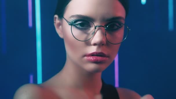 Modelo de neón retrato confiado mujer gafas graduadas — Vídeo de stock