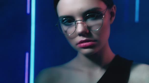 Neonlicht Porträt selbstbewusste Mädchen Brille blau — Stockvideo