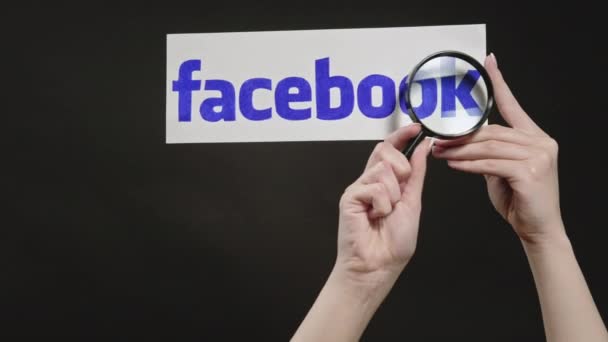 Facebook logo hand spying website magnifying glass — Stock Video