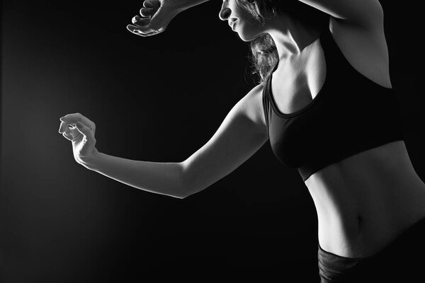 Sensual dance. Freedom tranquility. Athletic woman silhouette performing graceful movements isolated on black.