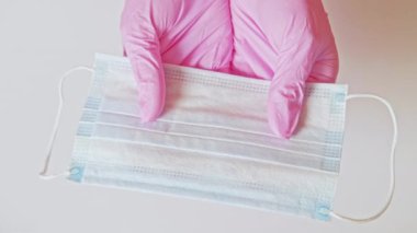 Yüz maskesi hijyen ekipmanı eller pembe eldivenler
