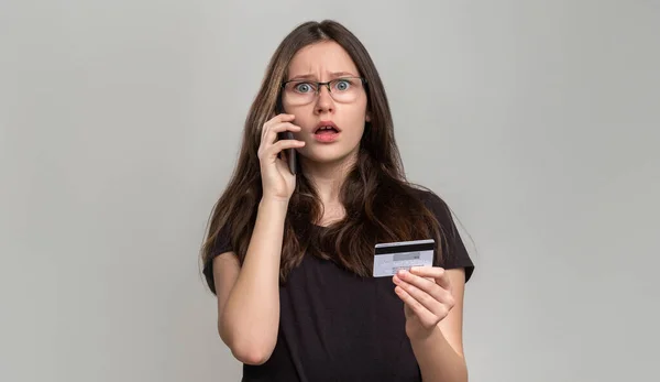 Bank fraud phone scam shocked woman credit card Stock Photo