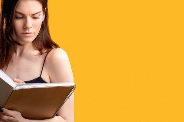 Not defteri yazan düşünceli bir kadın.