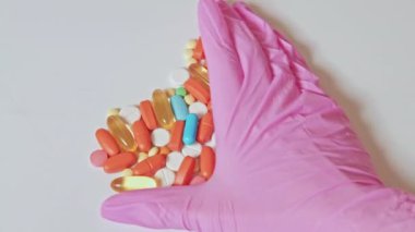 Eczacılık ilaçları pembe eldiven renkli hap veriyor.