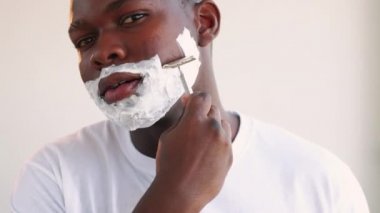 Adam kendine güvenen bir zenci tıraş makinesini tıraş ediyor.