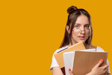 Akıllı öğrenci kadın not defterlerini inceliyor.