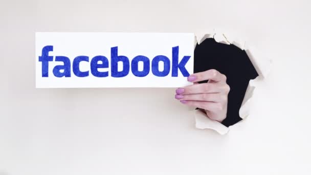 Facebook logo social media hand doorbraak papier — Stockvideo