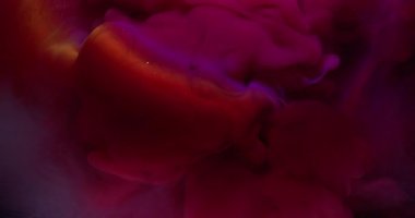 Mürekkep patlaması. Parlayan duman. Soyut sıvı karışımına yayılmış mor renkli girdap. Gleam ışını arkaplan ışığı odaklı olmayan lens.