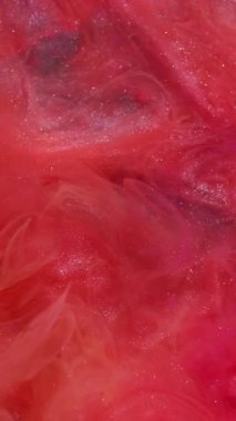 Dikey video. Parıldayan duman. Barut akışı. Sıvı içinde parlak sanat mürekkebi. Haze kırmızısı turuncu renk, parlak dalga soyut örtüsü, su arka planının yoğunluğu azaltılmış..