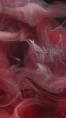 Dikey video. Sihirli buhar Duman mürekkebi. Kırmızı peçeli sıvı boya su fantezi dokusunu karıştırır. Soyut akış sıvı boya dumanı bulanık siyah arkaplan.