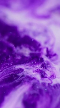 Dikey video. Mürekkep suyu. Mermer dokusu. Bulanık mor beyaz, parlak sıvı kimyasal sıvı soyut bokeh akrilik arka planda yayılıyor..