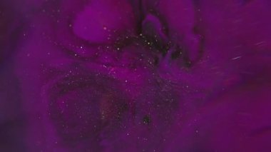 Parıldayan boya. Sıçrama sıvısı. Odaklanmamış pembe neon rengi mürekkep. Soyut yaratıcı ışık arkaplanı üzerinde yüzen koyu siyah parçacıklar..