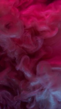 Dikey video. Parıldayan duman. Boya damlası. Sıvı içinde mistik sanat mürekkebi. Pembe, pembe, ışıl ışıl parlayan toz dalgası soyut bulanık boya çözeltisi arka plan.