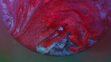 Boya dökülmüş. Renkli karışım. Odaklanmamış kırmızı neon yuvarlak doku akan damlacıklar parlayan su soyut mavi arkaplan üzerine yayılıyor.