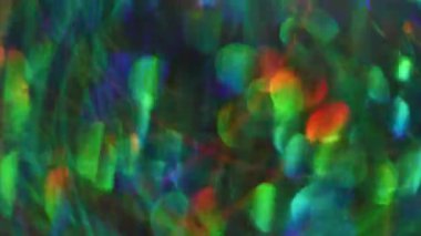 Bulanık karışık renkler. Parlak mercek parlıyor. Açık mavi turuncu kırmızı yeşil parçacıklar soyut arkaplanda bokeh etkisi ile parıldıyor.