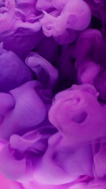 Dikey video. Duman dalgası. Sanat sıvısı. Renkli suda mor pembe neon boya patlaması. Soyut duman sıçraması. Odaklanmış arka plan dökülmesi..