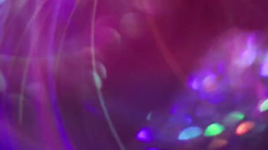 Havai fişekler parlıyor. Bulanık çoklu renk değişimi. Soyut sanat ışığı arka planında süzülen yeşil mor kurdele mercekleri yanıp sönüyor.