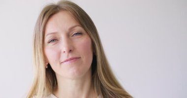 Cilt nemlendirici. Yaşlanma karşıtı tedavi. Beyaz fotokopi arkaplanındaki sağlıklı pürüzsüz yüze serum uygulayan güzel kadın..