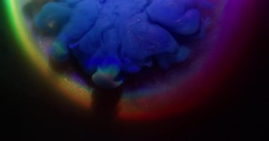 Parıltı akışı. Mürekkep girdabı. Mavi mor parlak akış siyah arkaplanda karışıyor. Bulanık parlak gökkuşağı ışığı kemerin etrafında soyut renkli su.