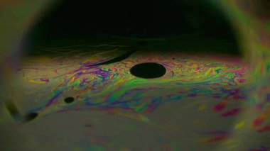 Parlak bulanık küre. Çember tüneli. Çok renkli yuvarlak mercek, benzin mürekkebi, sıvı, yanardöner pigment arka plan. Soyut yarı siyah gezegen çerçeve sıvısı.