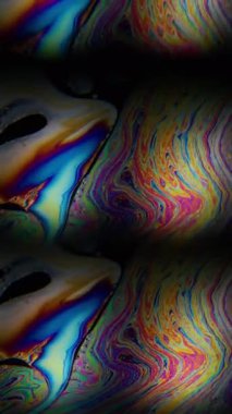 Dikey video. Gökkuşağı sıvısı. Sabun köpüğü. Sanat petrol zemininde neon pigment mürekkep karışımı. Soyut prizma bulanık ışık renk karışımı.