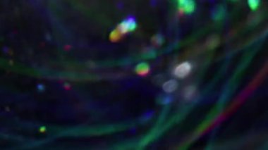 Bulanık çelenk. Parlak arkaplan. Girdap çok renkli, kırmızı parçacıklar parlıyor. Lens yanıp sönüyor. Sanatın koyu siyah soyutlaması üzerinde hareket ediyor..