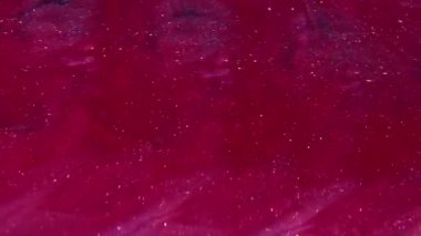 Parıldayan ışık. Sıçrama sıvısı. Soyut yaratıcı sanat arka planında yüzen odaksız kırmızı pembe renk kimyasal boya pigment parçacıkları.