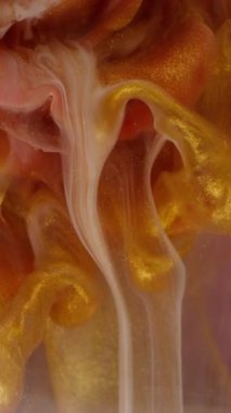 Dikey video. Gül arka planı. Köpüklü sıvı. Odaklanmamış bronz, altın, kırmızı, boya, mürekkep, su, sıvı, soyut, ışıltılı sanat eserleri..