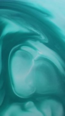 Dikey video. Su altında sıçrama. Akrilik akım. Soyut sanat arka planına yayılan sudaki mavi beyaz renkli mermer akış karışımı boya..