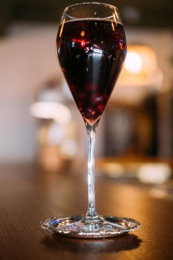 Şarap kadehi. Alkolik içki. Metal tabakta servis edilen kırmızı likör. Cabernet 'in zarif cam sunumu restoran tezgahında.
