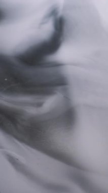 Dikey video. Sanat sıvısı. Akış boyası. Odaklanmamış gri mürekkep rengi su mermeri ıslak doku dalgalı kimyasal sıvı soyut arkaplanda akıyor.