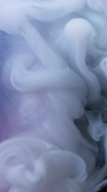 Dikey video. Sis dalgası. Mürekkep dumanı. Beyaz sıvı girdap fırtınası patlaması. Boya sanatı, su peçesi. Renkli, soyut bir fantezi. Odaklanmış arka plan..