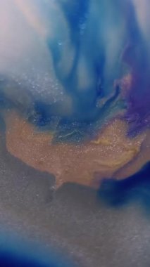 Dikey video. Mermer dokusu. Köpüklü sıvı. Soyut sanat arka planında yüzen su parıltılı sıvı akışında çözünmüş mavi sarı renk boya.