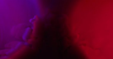 Renkli sis. Mürekkep buharı. Mor kırmızı ışık suyunda boya dalgası. Fantezi parlayan damla patlaması soyut neon gölgesi bulanık arkaplan.